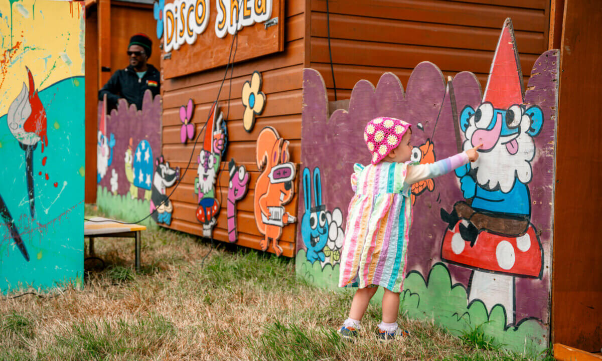Child playing with family friendly wall art in the We Out Here family area.